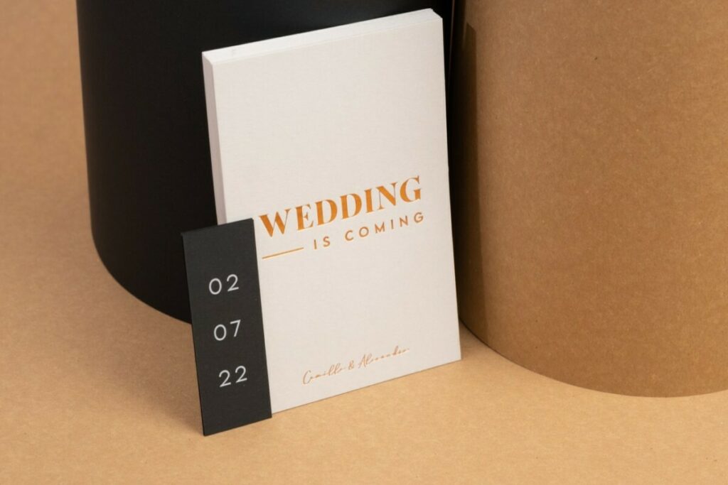 Wedding is comming – Save the date A6 en dorure à chaud Cuivre Saxon 6735 avec débossage sur Colorplan Pale Grey 540gr – Etiquette assortie impression blanche numérique du Sirio Black 290gr:m2