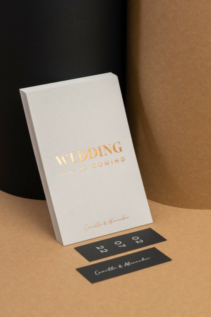 Wedding is comming – Save the date A6 en dorure à chaud Cuivre Saxon 6735 avec débossage sur Colorplan Pale Grey 540gr – Etiquette assortie impression blanche numérique du Sirio Black 290gr:m2