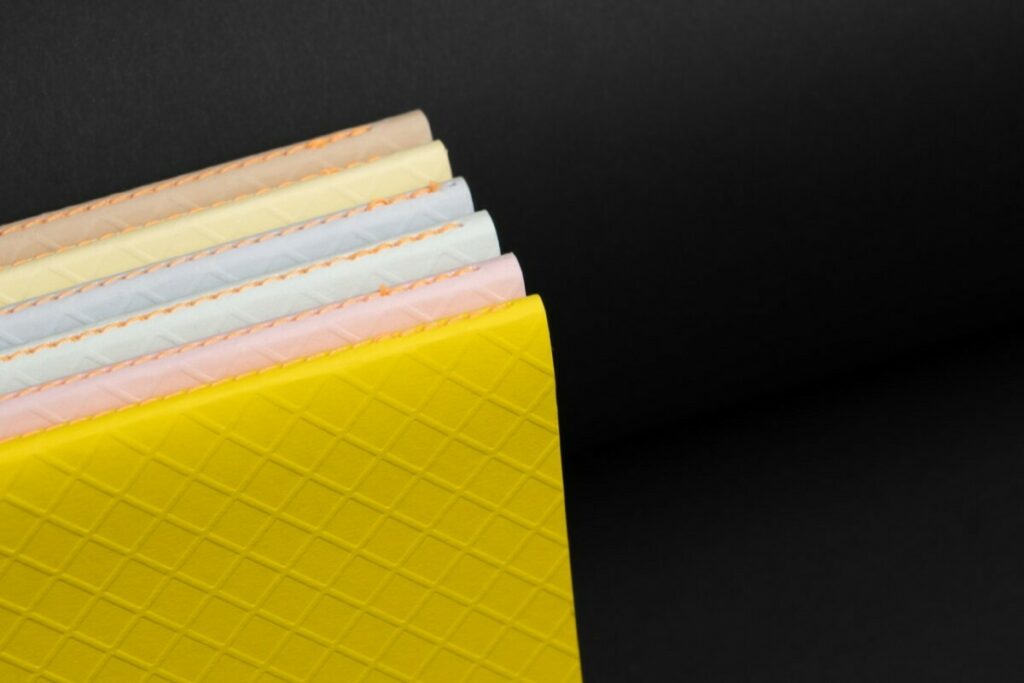 Collection de Carnets en couture singer Orange au pli et couverture embossée Colorplan 270gr/m2 – Stone, Sorbet Yellow, Azure Blue, Powder Green, Candy Pink, Factory Yellow