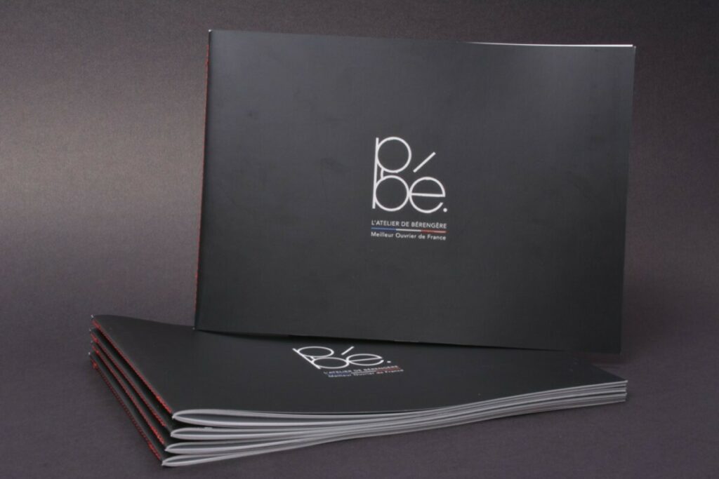 Brochure Opticien format paysage – Pelliculage mat et vernis 3D – Couture singer rouge au pli