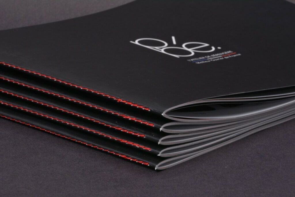 Brochure Opticien format paysage – Pelliculage mat et vernis 3D – Couture singer rouge au pli