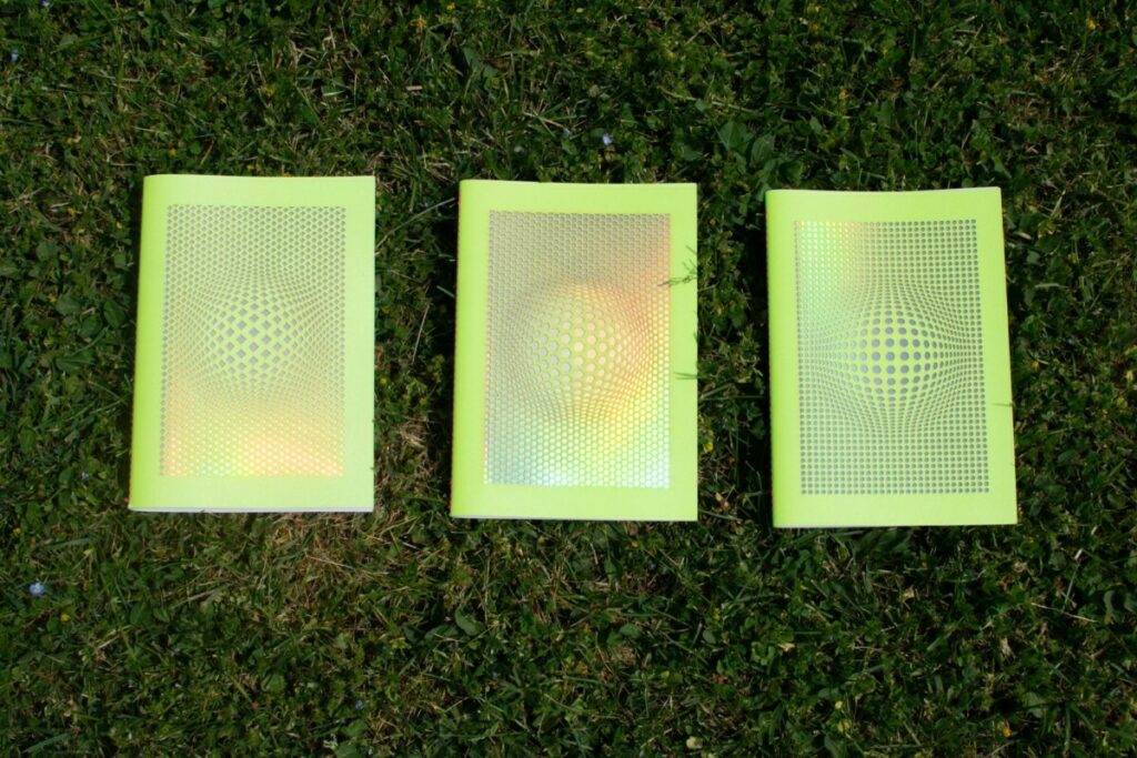 Collection de carnets de notes Illusonautes – Gmund action nuclear acid – découpe laser motifs holographiques laser – Reliure couture singer Rose Fluo – impression Pantone Rose fluo PMS 806