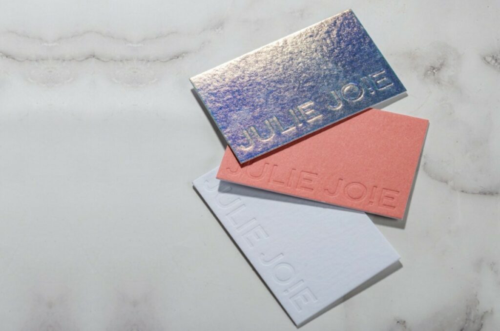 Carte de Visite agence évènementielle holographique avec débossage pur – Création Pack- Contre collage duplex 700gr/m2 – Impression Pantone Terre de feu