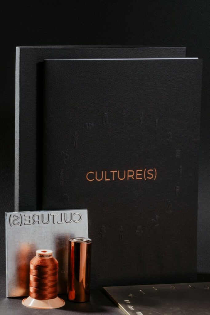 Brochure artiste XXL A3 fermé en gaufrage 3D avec boite cloche rigide assortie – Reliure couture singer orange – Gmund Leather Mocha 350gr – Marquage à chaud Cuivre – Pur Coton 120gr/m2