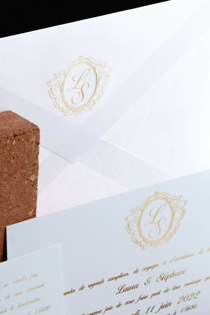 Faire-part de mariage avec monogramme en Dorure à chaud Or galbé – Enveloppe C5 sur mesure avec patte triangle et motif en marquage à chaud nacré – Olin Regular Extra blanc