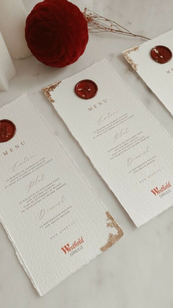 Menu soirée inauguration – Couverture  calque – Ruban satin rouge avec cachet de cire – Dorure à la feuille d’or – Papier coton Arches bords frangés
