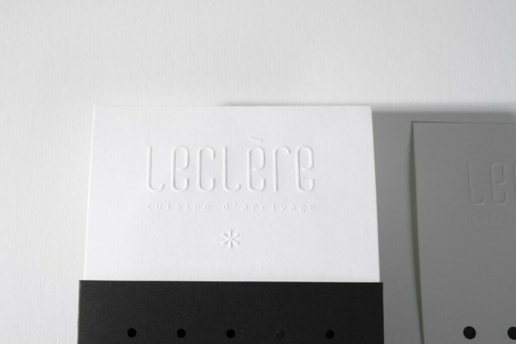 Menu avec pochette pour restaurant d’arrivage haut de gamme – Embossage en relief du logo – Century coton wove 160g et Sirio collor black 290g