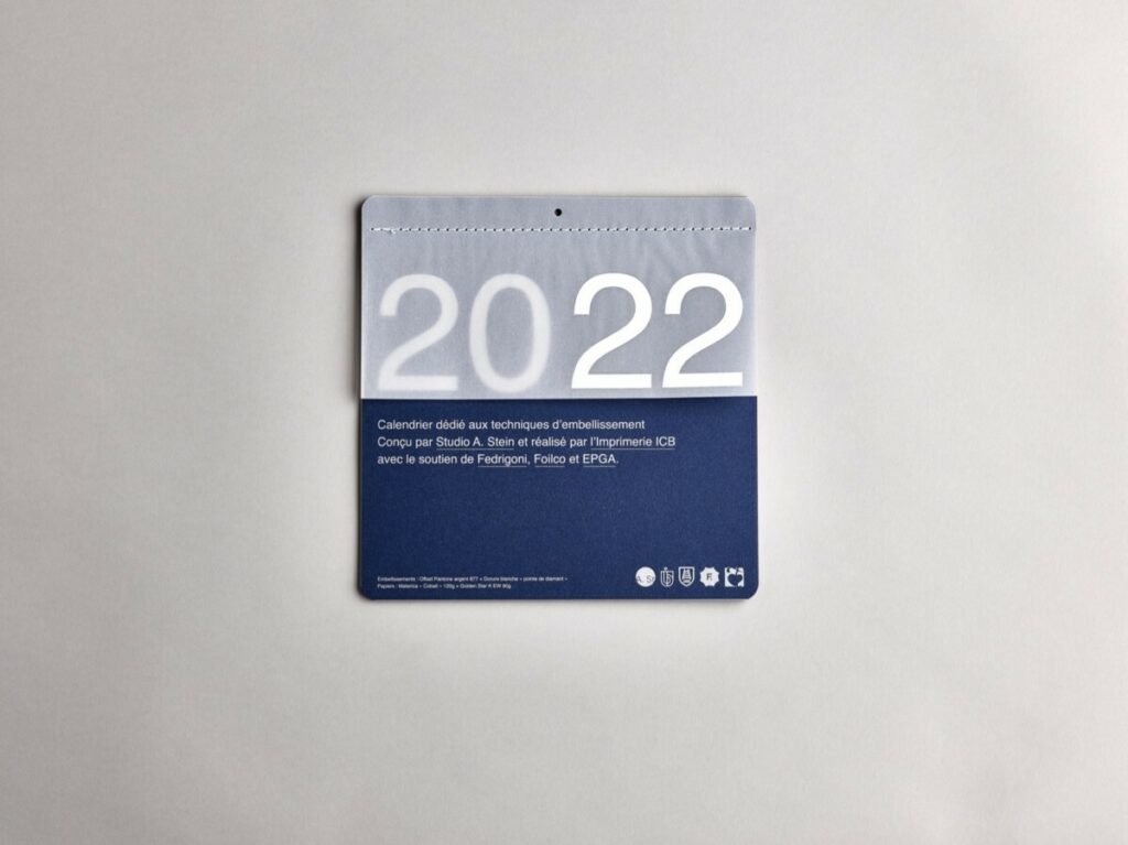 Calendrier collaboratif carré avec reliure Singer à plat et découpe 4 angles arrondis – Materica – Calque – Dorure à chaud – Pantone Argent