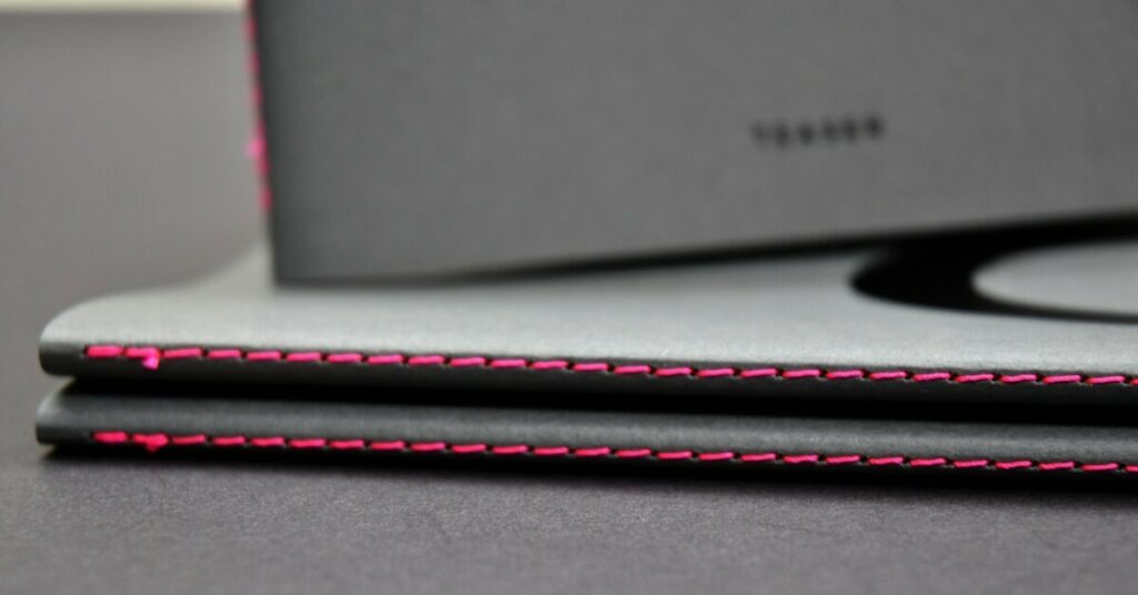 Livre de présentation Architecte avec couverture à rabats – Reliure en couture Singer rose néon – Marquage à chaud galbé Noir brillant – Colorplan Dark Grey 270gr