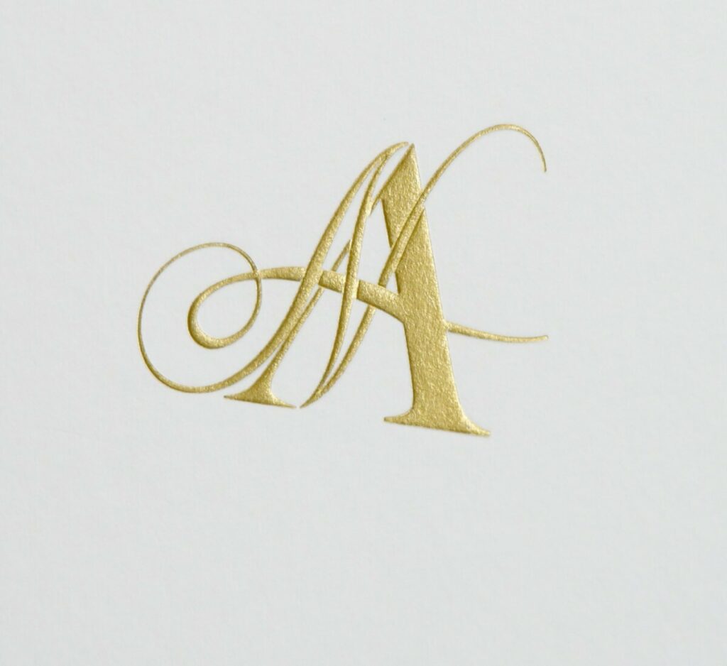 Menu livret pour cérémonie avec cordelière pompom assortie dorée – Old Mill Bianco 300gr/m2 – Monogramme en dorure galbée OR Mat