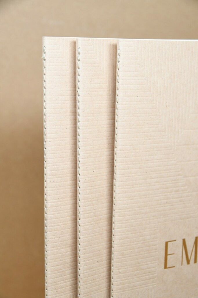 Book de présentation promoteur immobilier – Marquage à chaud or mat et débossage motifs en creux sans impression – Kraft recyclé cocoa shell 300g – Reliure en couture singer ton sur ton – 16 pages intérieur couché mat 300g
