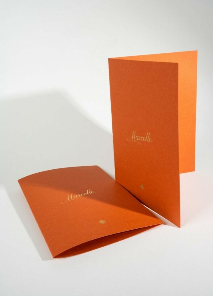 Couverture porte menu sur papier terracotta avec marquage à chaud or sable 429 en débossage – Materica Terra Rossa 360gr