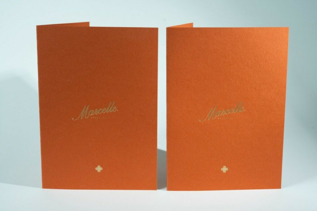 Couverture porte menu sur papier terracotta avec marquage à chaud or sable 429 en débossage – Materica Terra Rossa 360gr