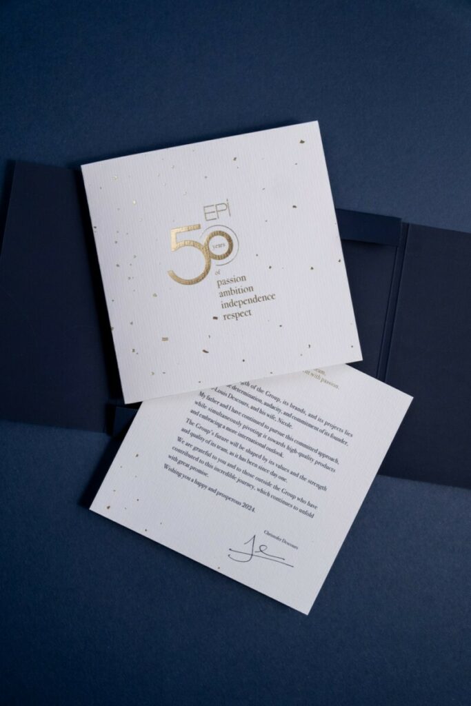 Carton d’invitation 50ans d’histoire avec une pochette a rabats et découpe sur mesure – Marquage à chaud transparent du château sur Sirio color dark blue – Invitation sur papier de création Vergé avec dorure à chaud or brilante